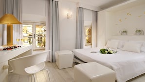 Ein modernes Hotelzimmer mit einem Bett, einem Schreibtisch, einem Sessel und einem kleinen Tisch mit einer Lampe.