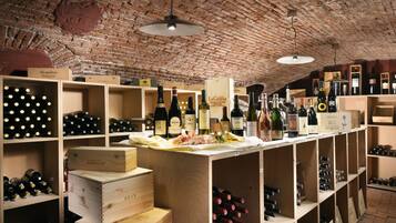 A wine cellar with wooden shelves and racks, displaying various wine bottles and boxes.