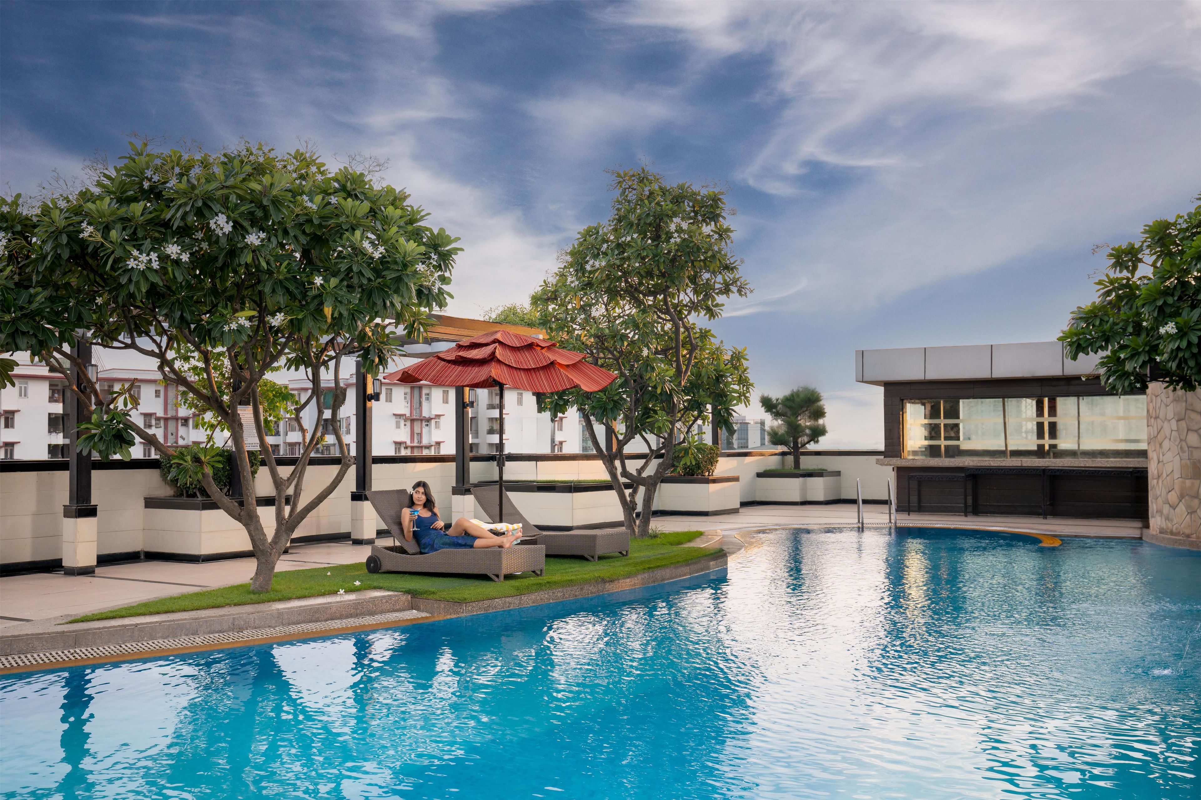 A swimming pool with lounge chairs and a covered seating area.