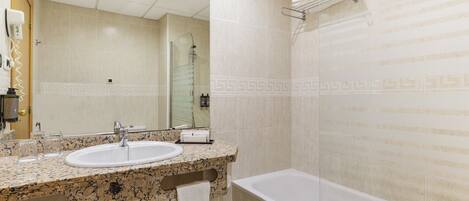 Une salle de bain avec un lavabo, un miroir et une baignoire.