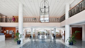 A spacious lobby with a high ceiling, a central chandelier, and potted plants. - Hotel Best Mojácar (Mojacar)