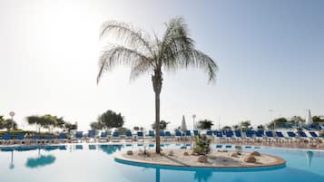 Een buitenzwembad, parasols voor strand/zwembad
