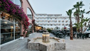 An outdoor area with a fountain, seating, and a building with balconies. - Hotel Best Mojácar (Mojacar)