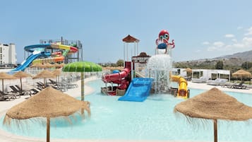 Una piscina al aire libre, sombrillas, sillones reclinables de piscina