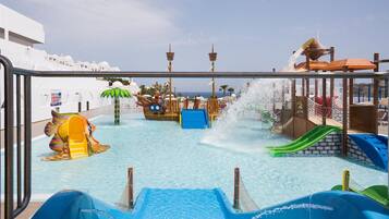 Una piscina al aire libre, sombrillas, sillones reclinables de piscina