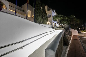 Un bâtiment moderne doté d’un toit en pente, d’un mur de soutènement en pierre et d’un chemin pavé.