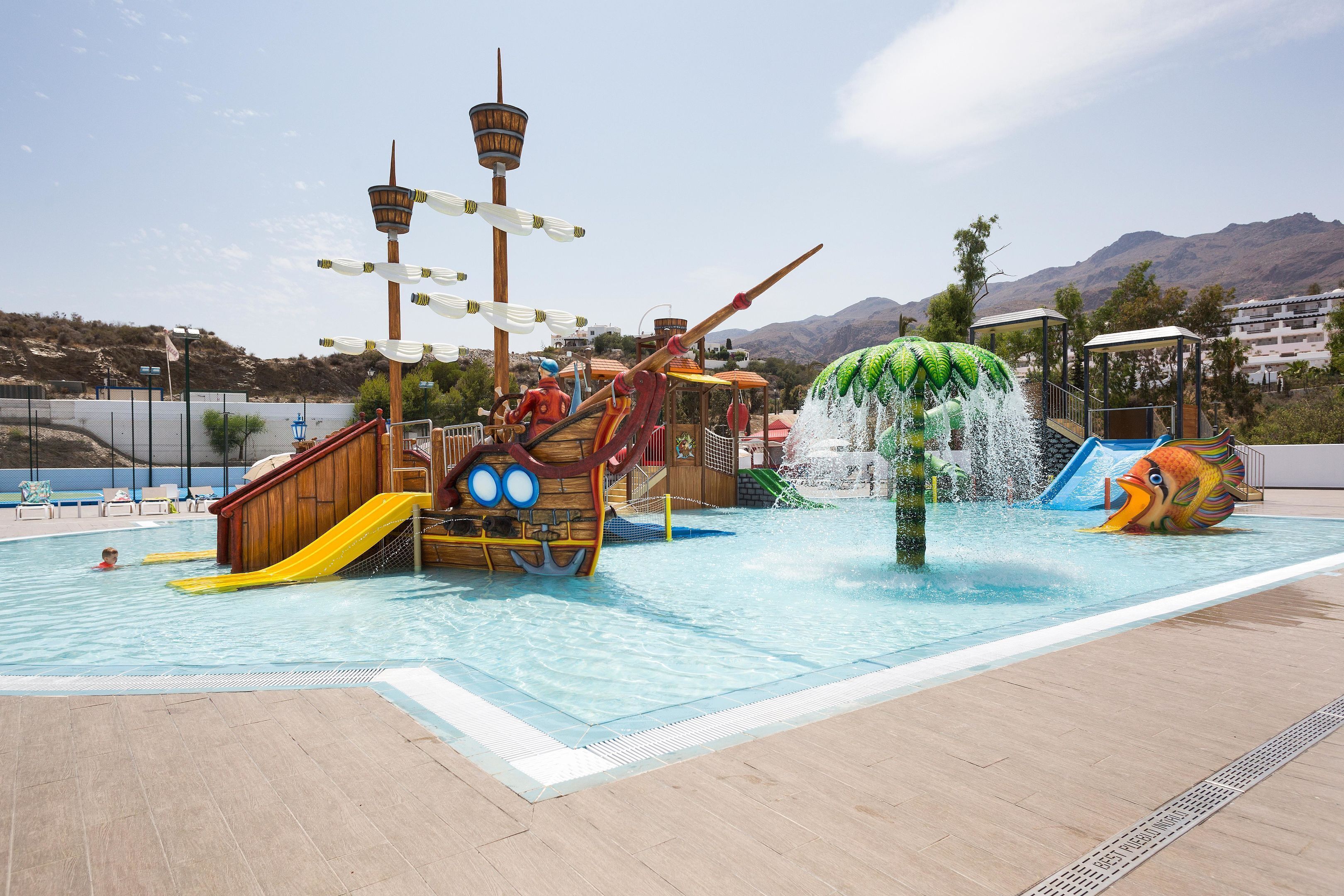 Parque aquático com área de recreação temática de navio, escorregador de água e piscina.