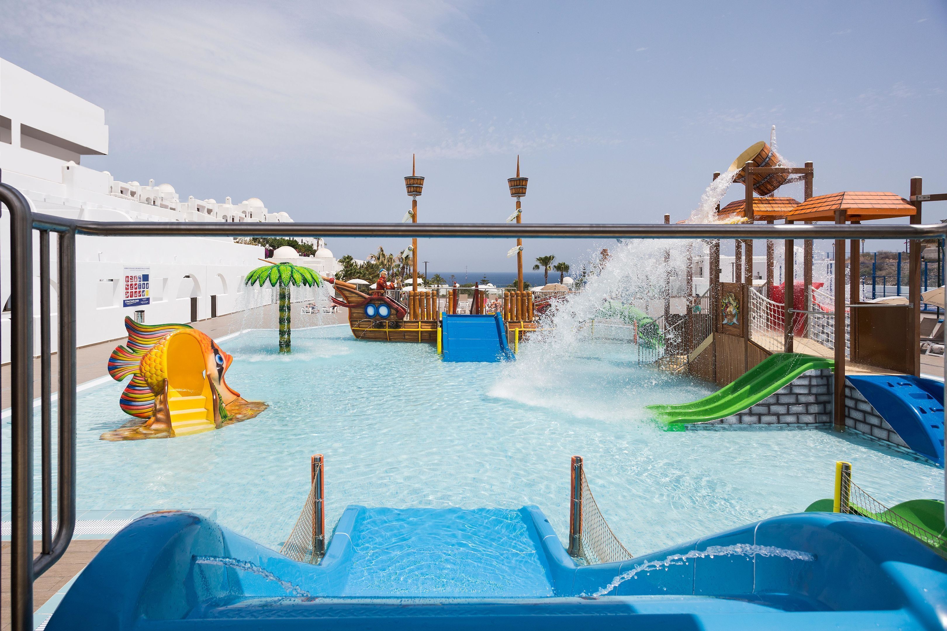 Een buitenzwembad, parasols voor strand/zwembad