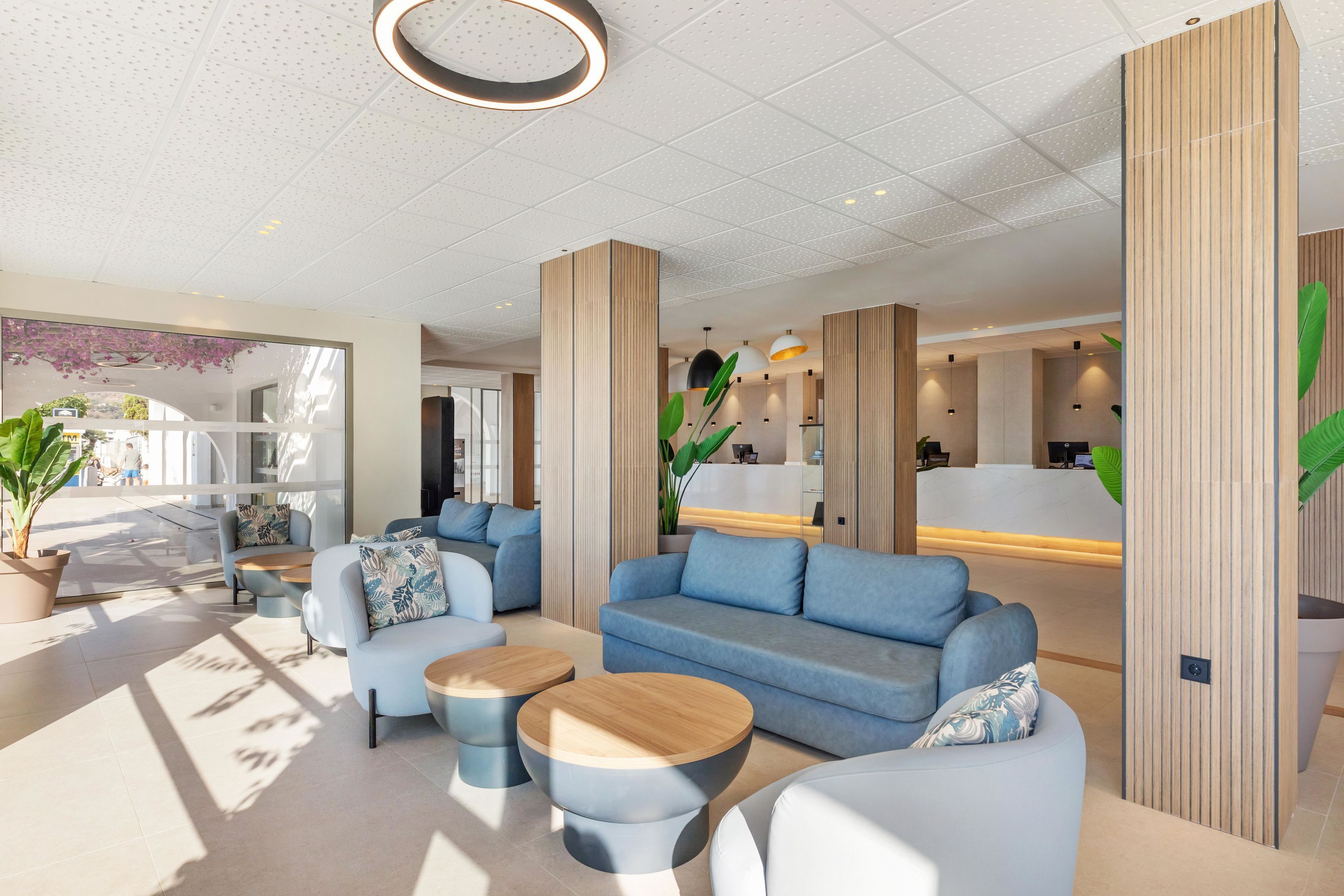 Een moderne lobby met zithoeken, een receptiebalie en grote ramen die natuurlijk licht binnenlaten.
