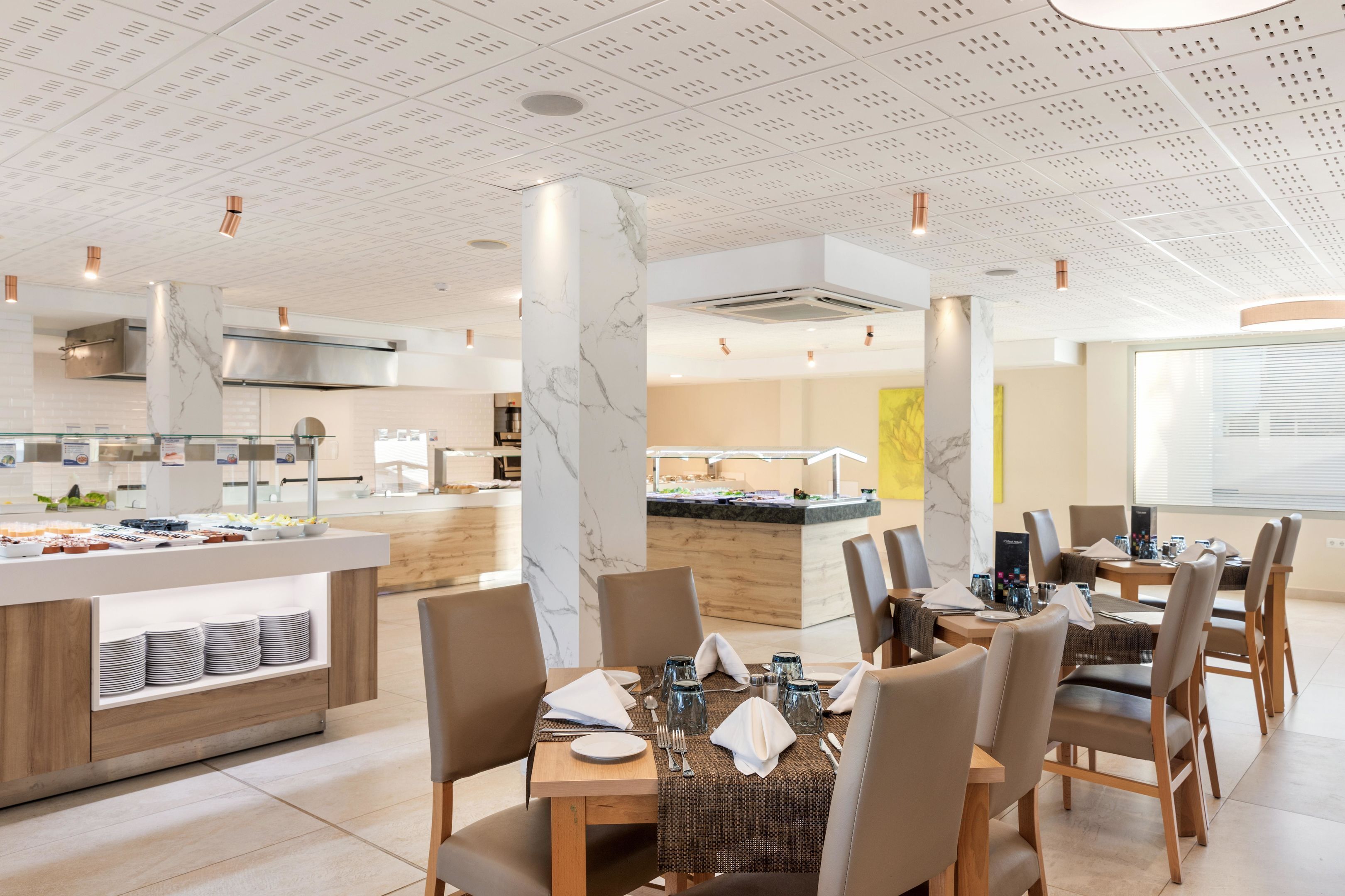 A modern dining area with marble columns, a buffet counter, and a clean, contemporary design.