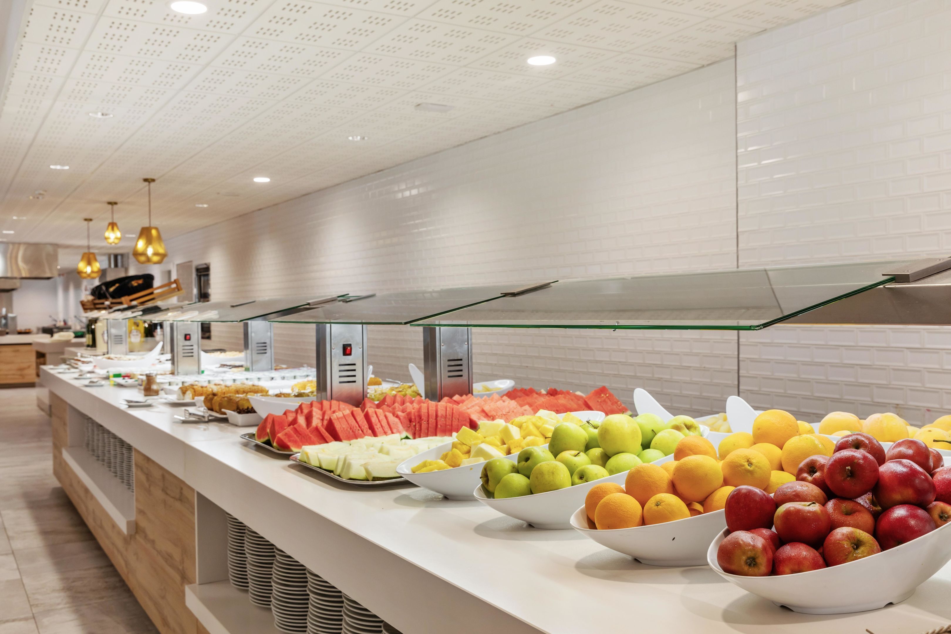 A buffet with various fruits and pastries.