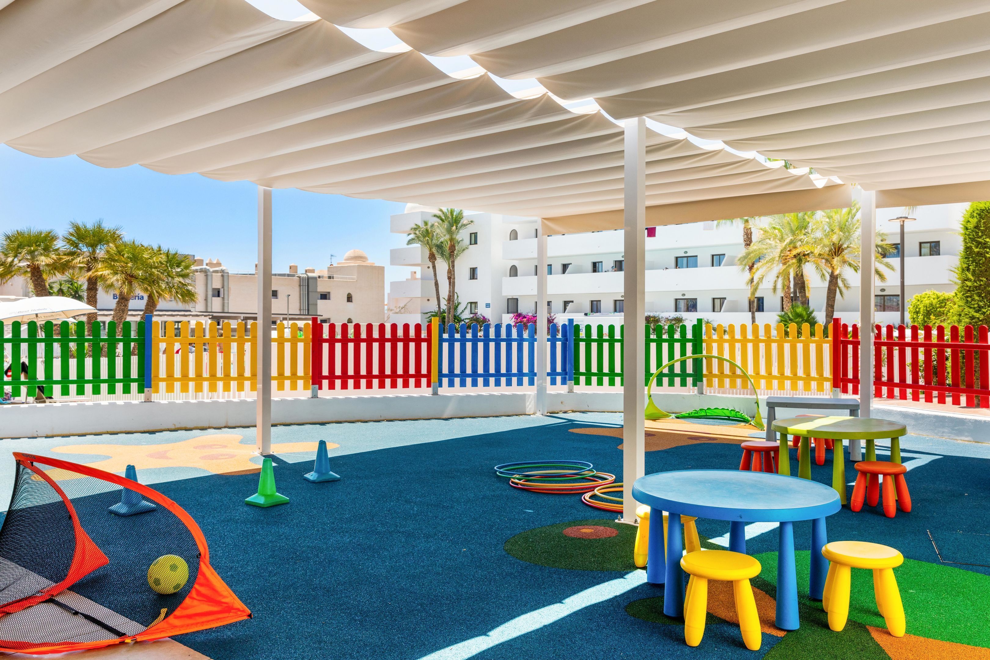 A children's play area with colorful play equipment, including a net, cones, and a ball.