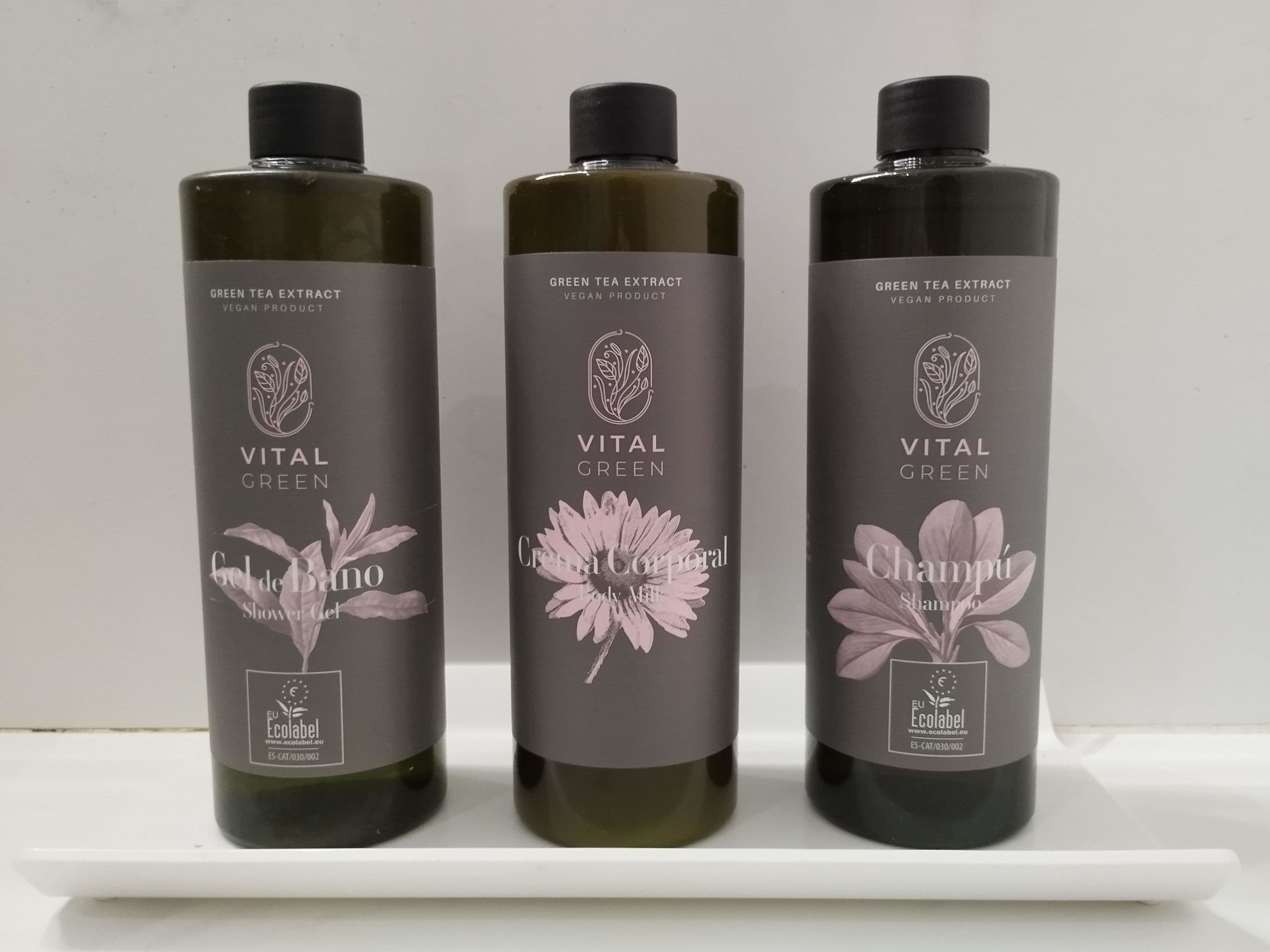 Três frascos de Vital Green Green Tea Extract, produto vegano, sobre uma prateleira branca.