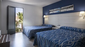 Habitació d'hotel amb dos llits, una finestra gran i vista a palmeres.