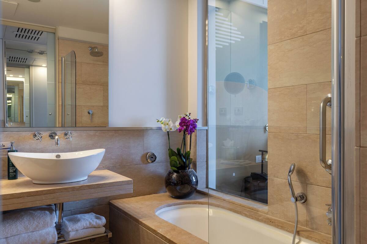 A modern bathroom with a freestanding bathtub, a large mirror, and a glass shower enclosure.