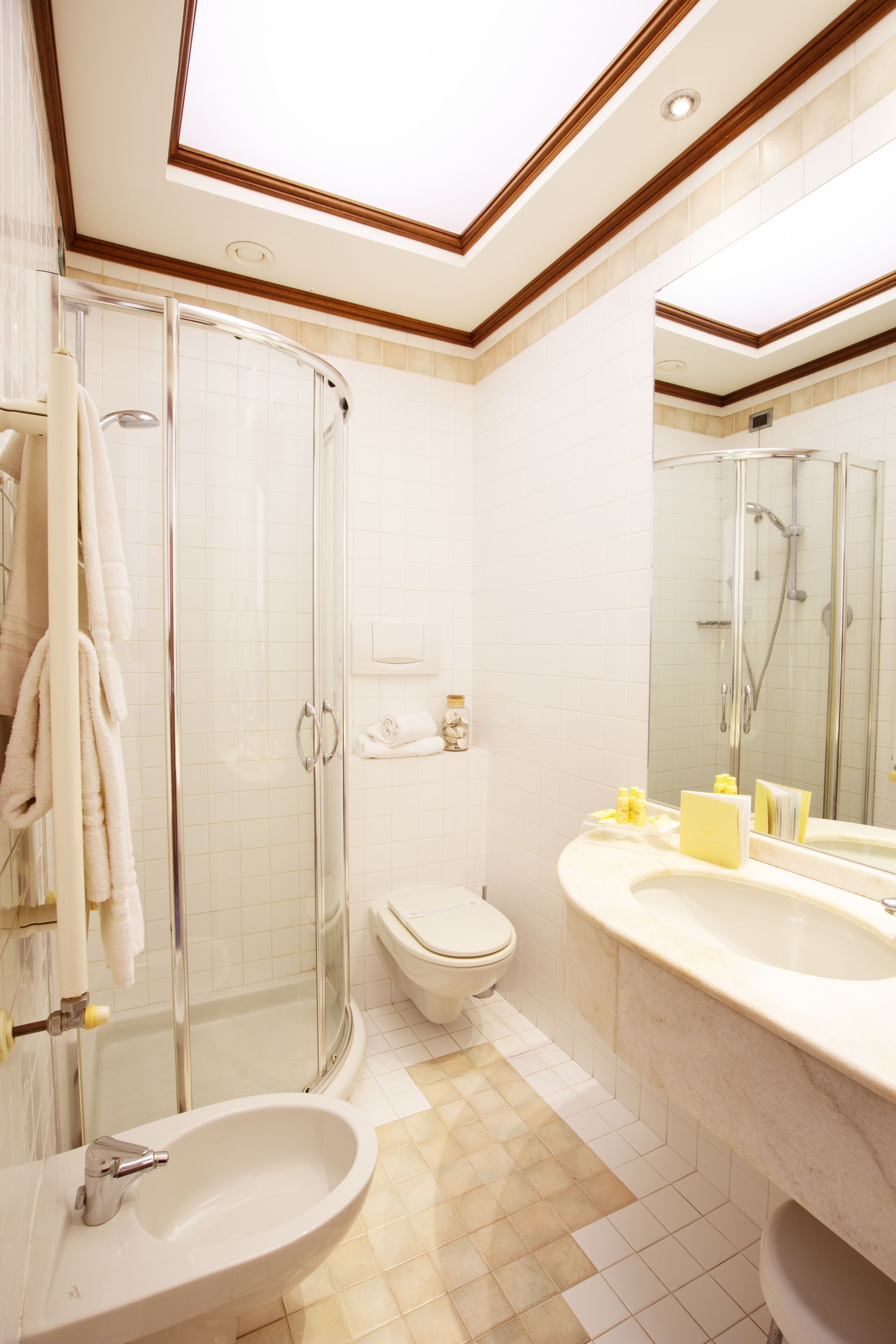 Une salle de bain moderne avec une douche à parois de verre, un lavabo blanc et un grand miroir.