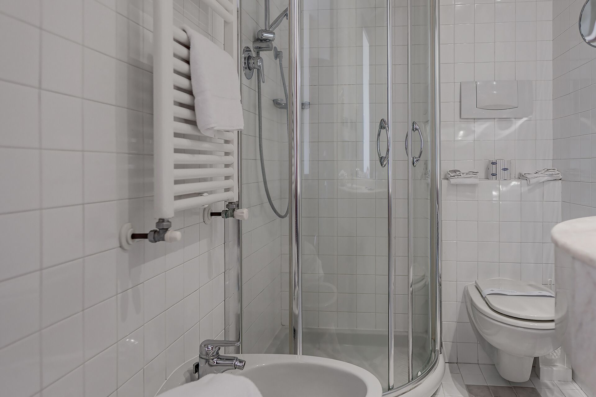 Un baño moderno con ducha acristalada, inodoro blanco y bidé.