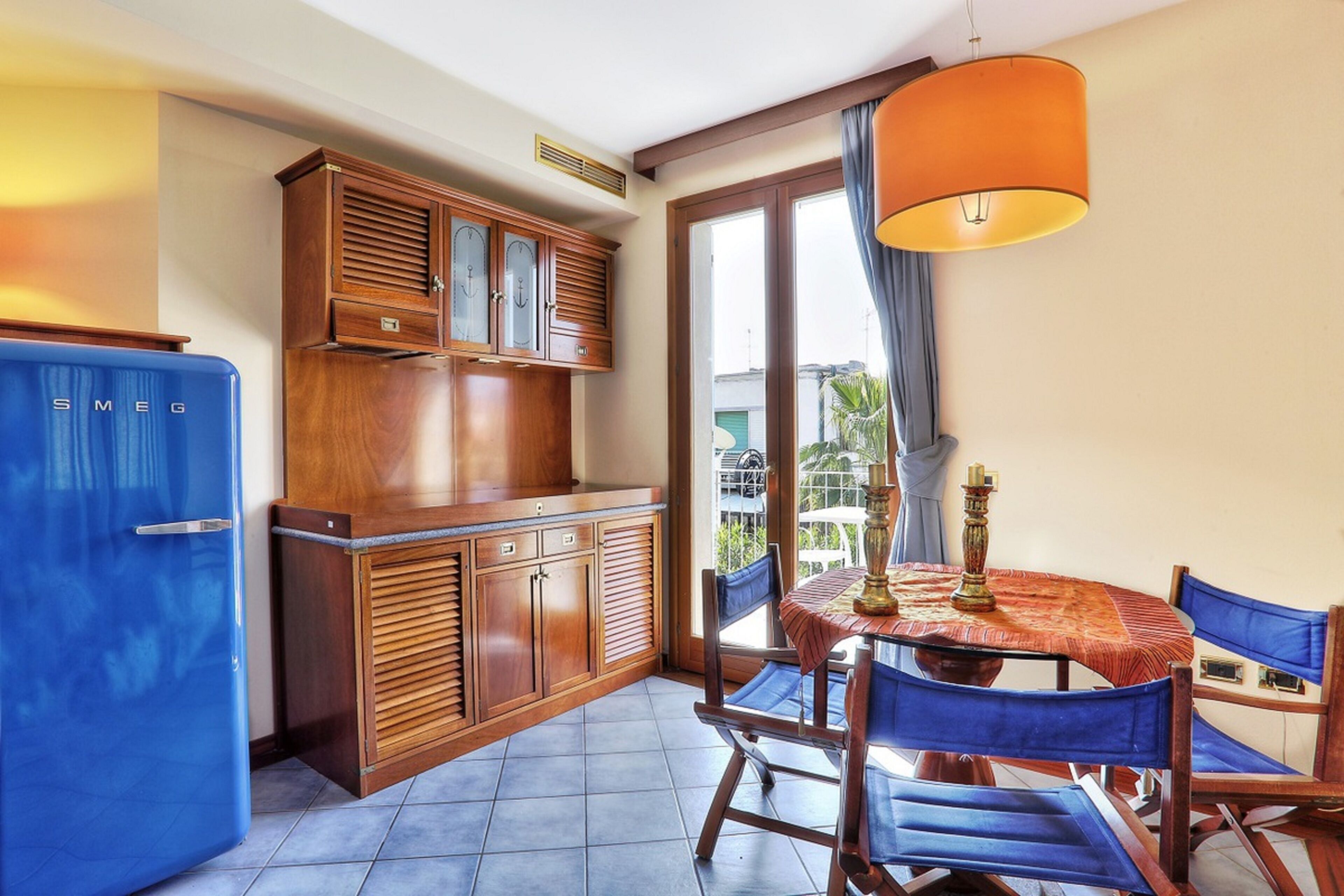 A compact kitchen with wooden cabinets and a blue refrigerator.