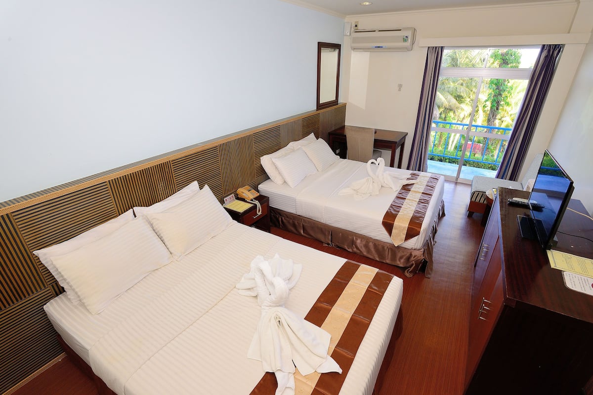 Ein Hotelzimmer mit zwei Betten, einem Schreibtisch und Blick ins Freie.