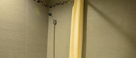 Un baño con bañera, inodoro y ducha.