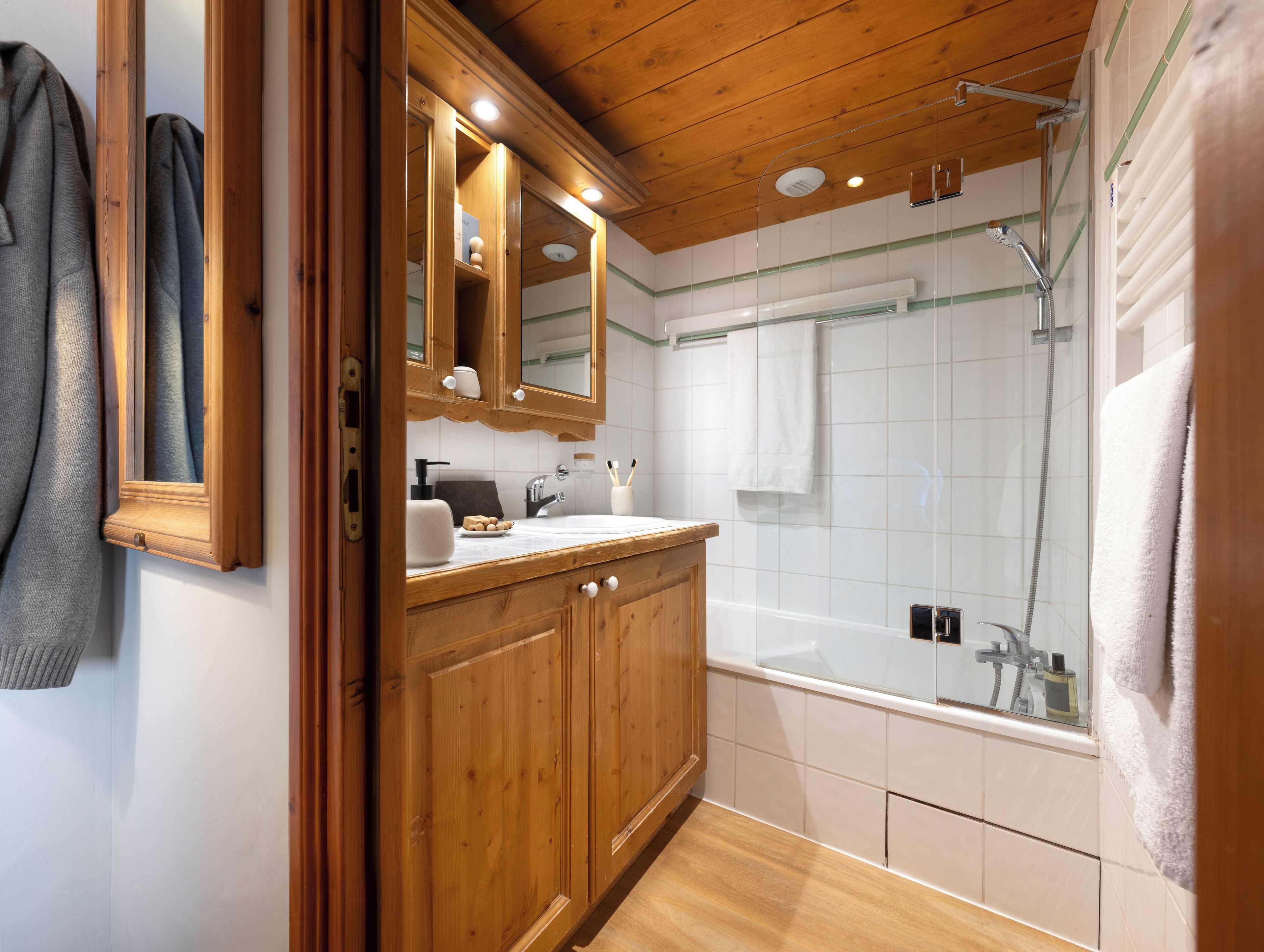 A wooden vanity with a mirror, a sink, and a towel rack.