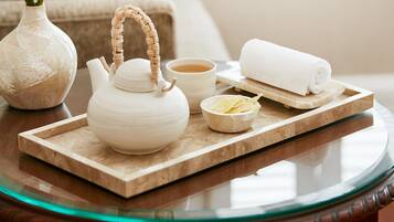 Una mesa con tetera, taza y toalla enrollada, indicando una disposición para servir té.