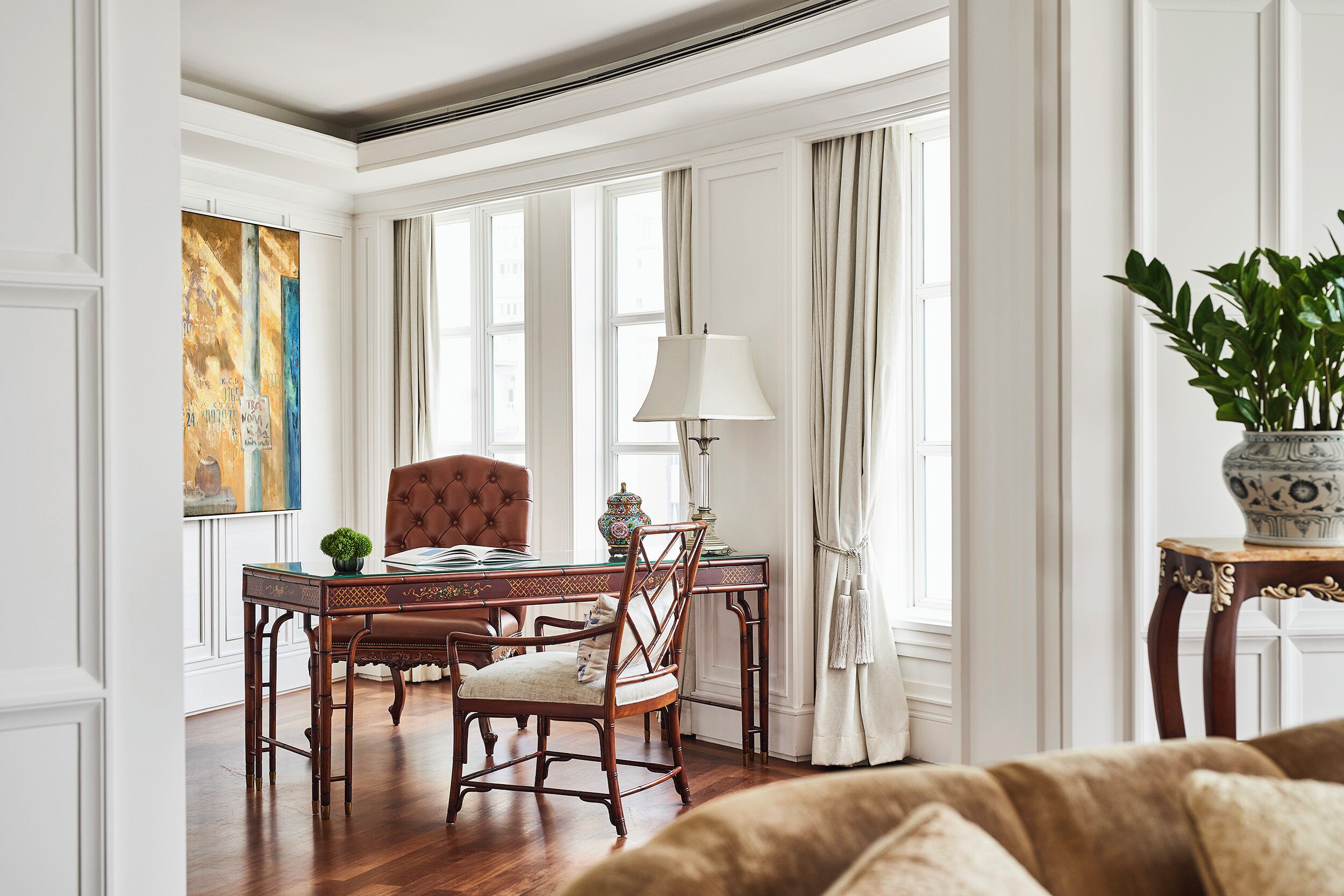 Una habitación con una mesa de comedor de madera, sillas, una lámpara y una planta en maceta.