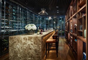 A bar area with a marble counter, wine glasses, and bottles. - Park Hyatt Saigon (Ho Chi Minh City)