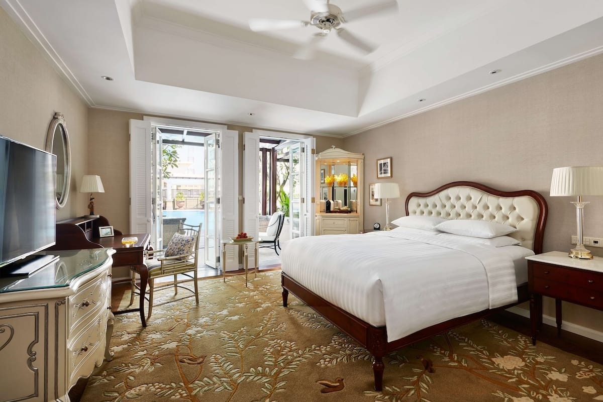 A hotel room with a bed, a television, a desk, and a chair.