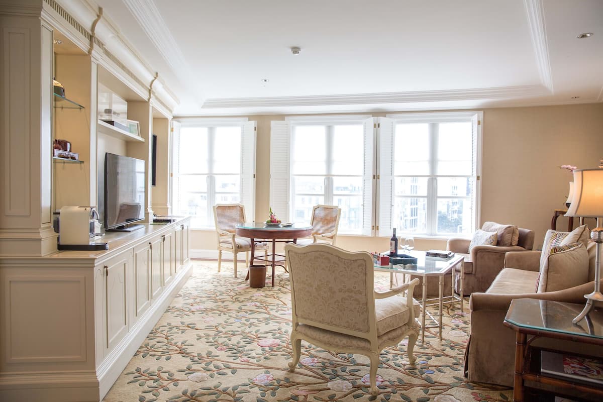 Un salón espacioso con un gran ventanal, una zona de comedor y un sofá.