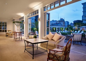 A modern interior with a sofa, chairs, a table, and a large window offering a city view. - Park Hyatt Saigon (Ho Chi Minh City)