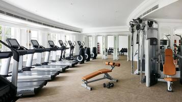 A gym with treadmills, weight machines, and a bench.
