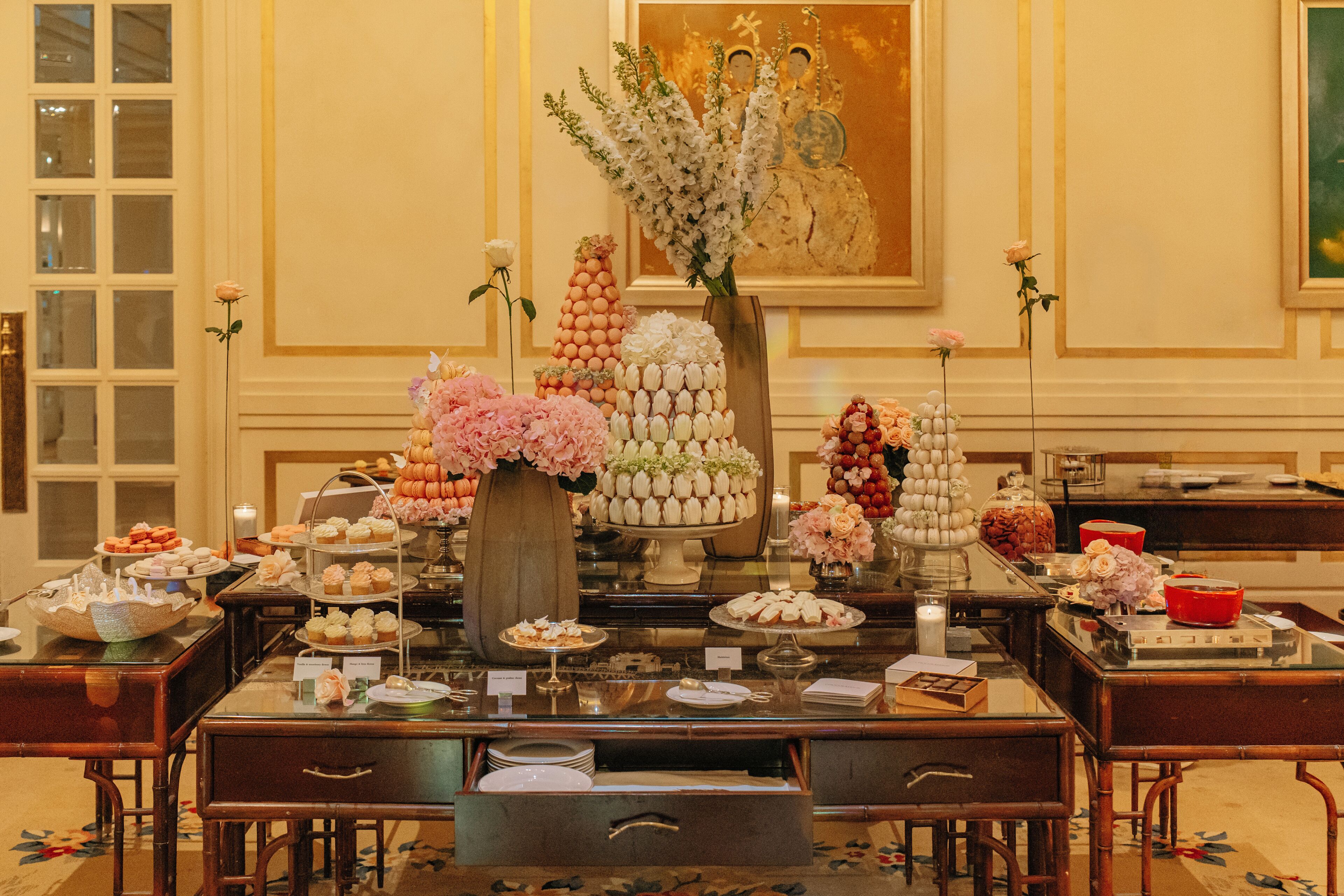 A buffet setup with various food items and floral arrangements.