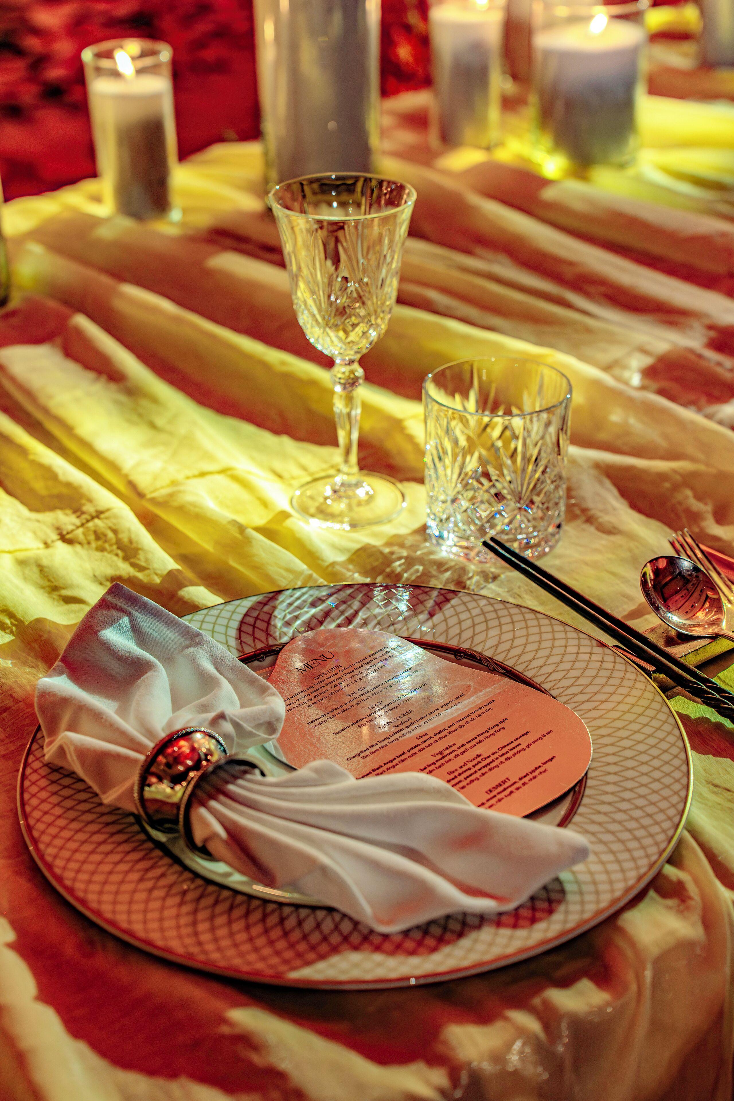 A table set for dining with a menu, cutlery, and glasses.