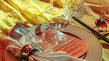 A table set for dining with a menu, cutlery, and glasses.