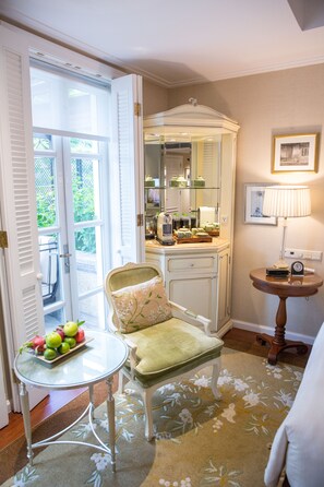 Une pièce comprenant une table à manger, une chaise, une petite table ronde avec une lampe et un miroir placé au-dessus d’un comptoir.