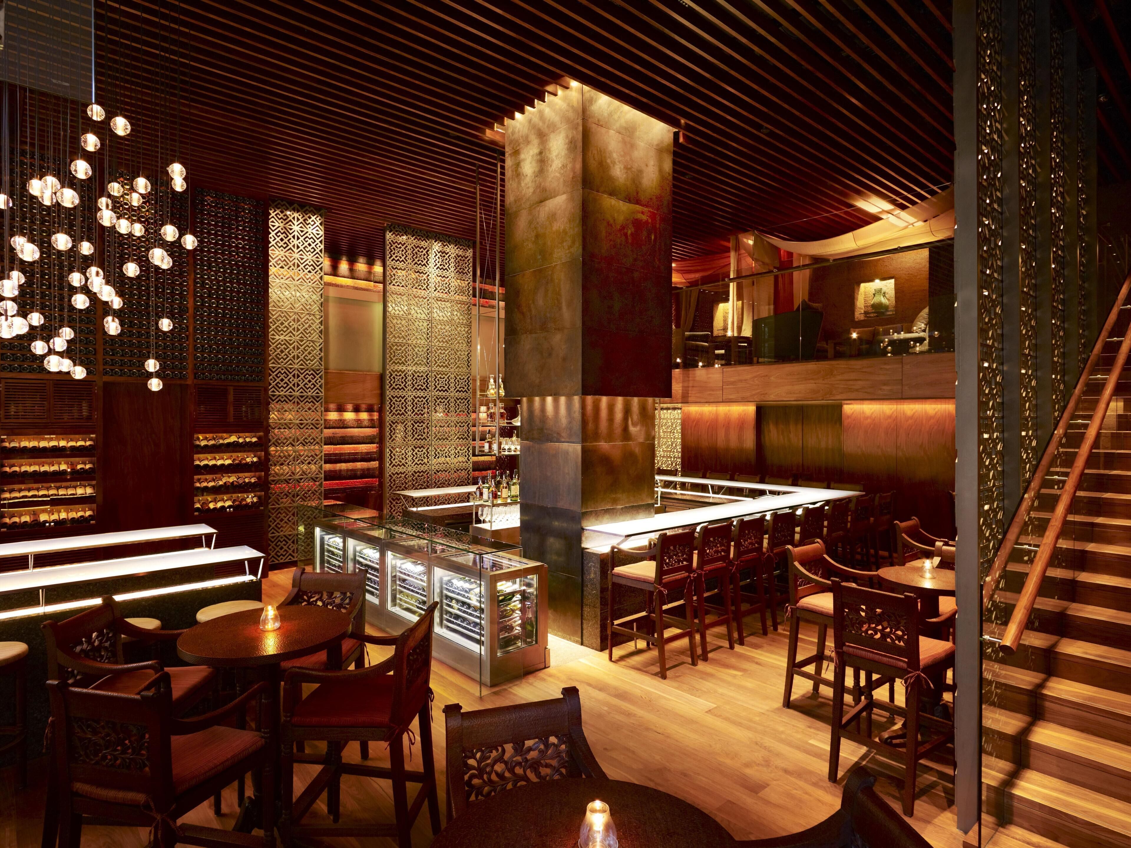 A modern interior with a bar area, seating, and a staircase.