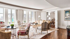 A spacious living room with large windows, elegant furniture, and a view of the city.