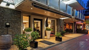A hotel entrance with a stone facade, large potted plants, and a sign reading "The Spire". - The Spire Hotel Queenstown (Queenstown)