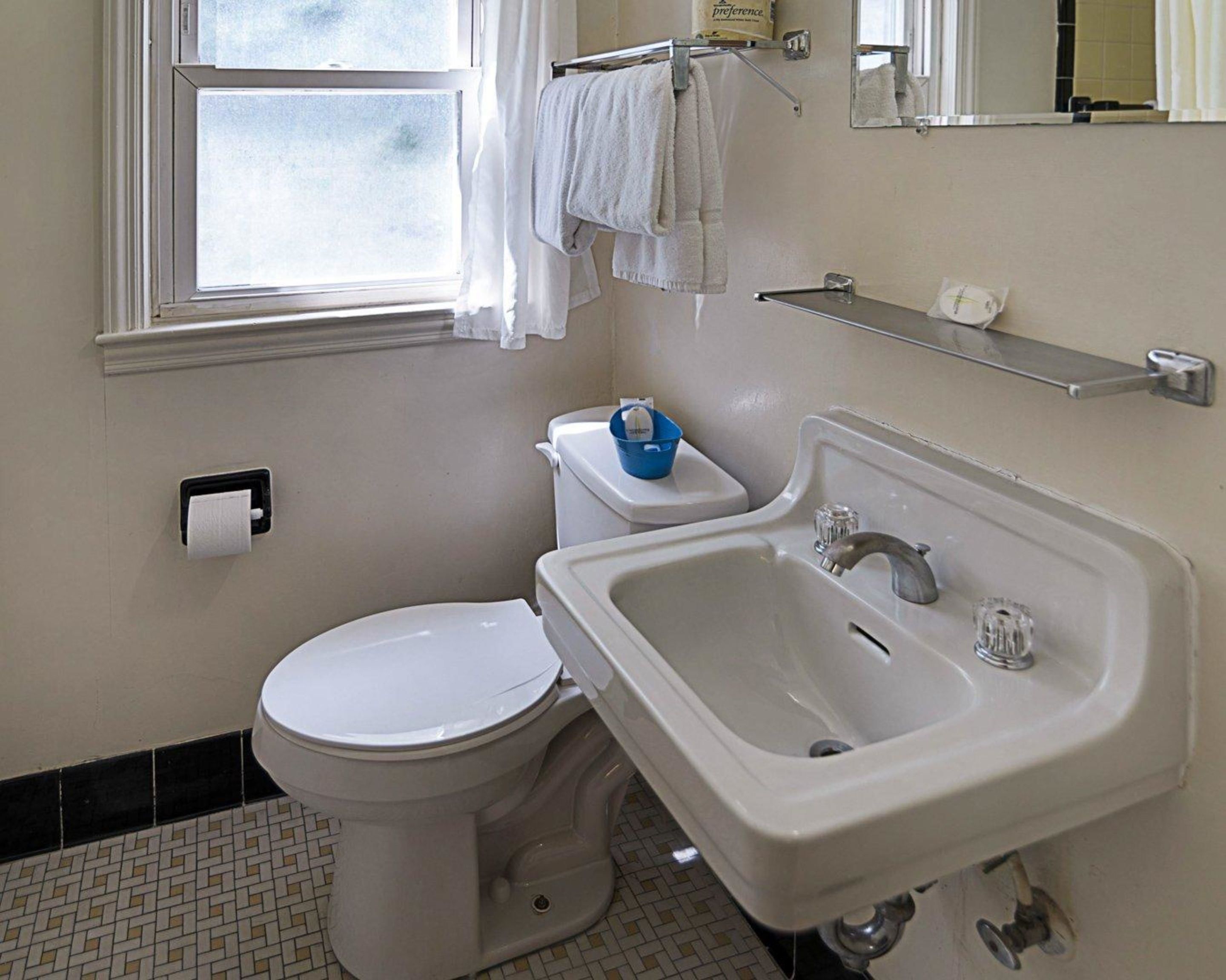 Un baño con inodoro, lavabo y ventana.