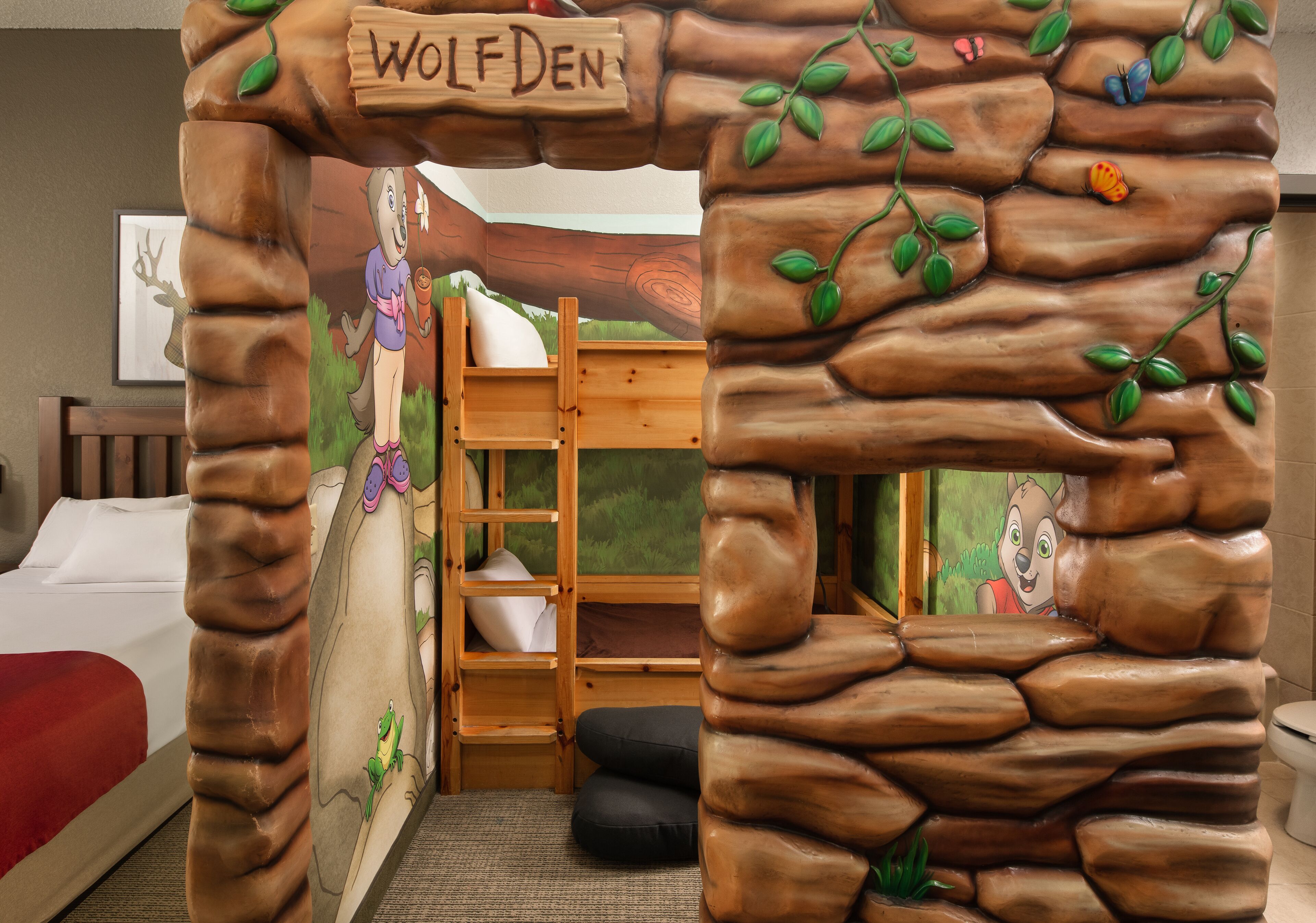 A children's room with a bed, a wooden ladder, and a mural of a forest scene.