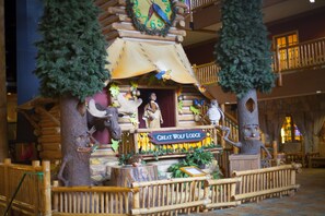Exhibició temàtica de Great Wolf Lodge amb una estructura de fusta, arbres i diverses figures d'animals.