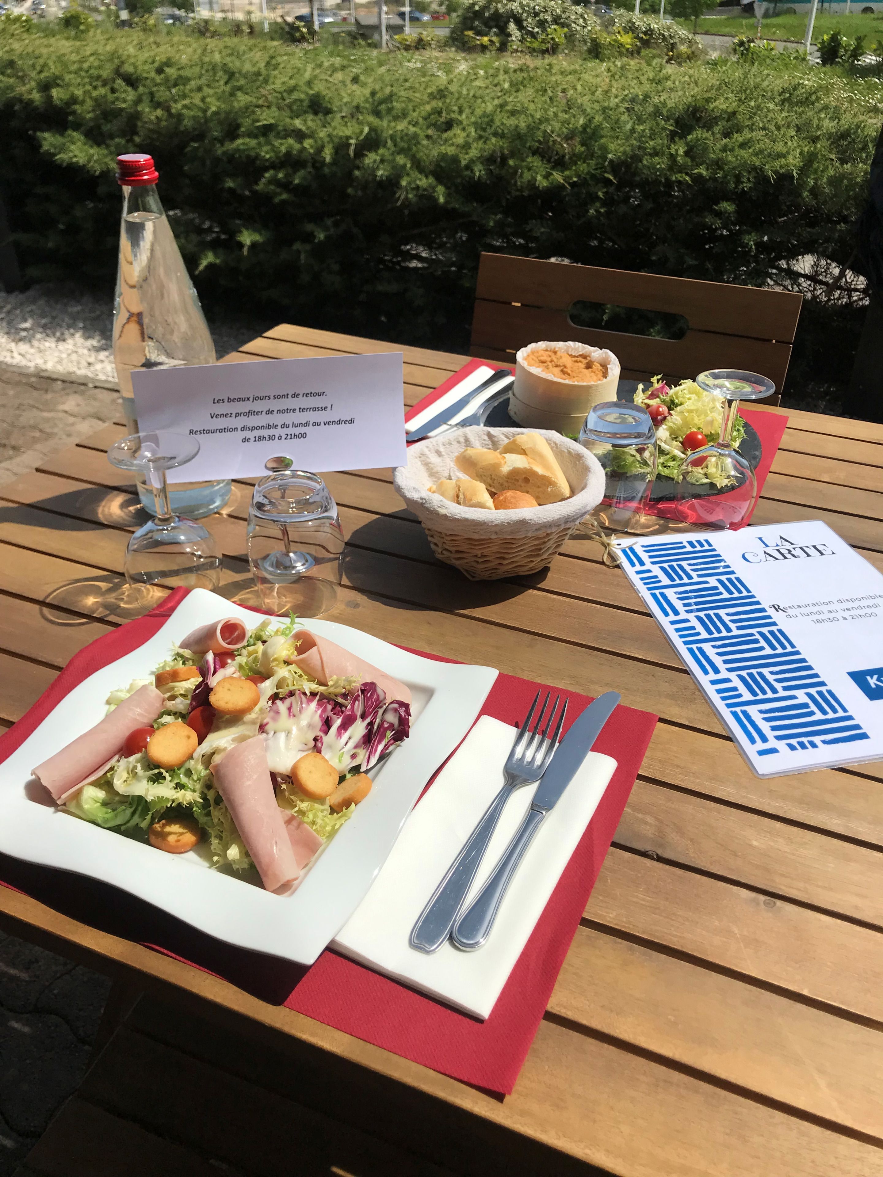 A table set with a meal, a bottle, and a menu.
