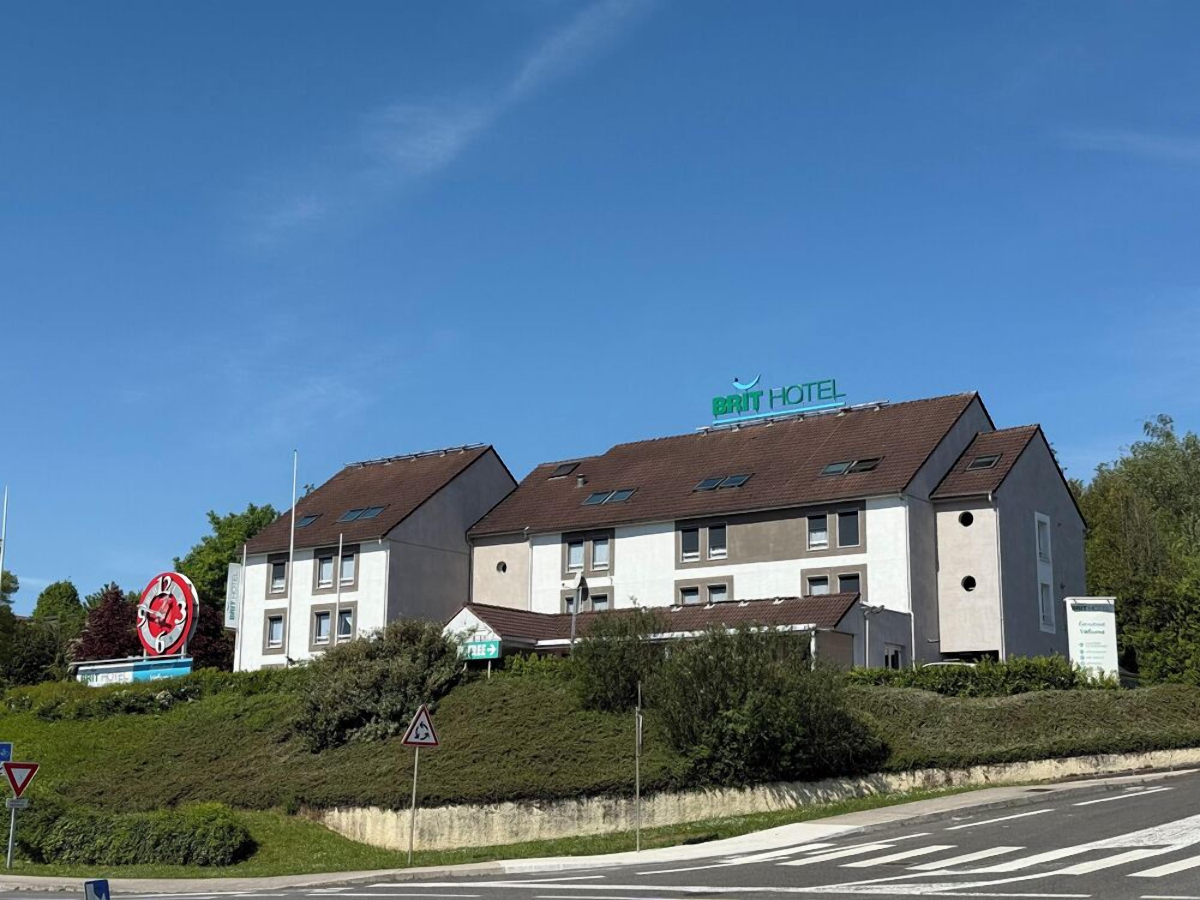 Un hôtel de la chaîne BRIT au design moderne, caractérisé par un toit plat et de nombreuses fenêtres.