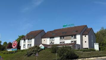 Un hôtel de la chaîne BRIT au design moderne, caractérisé par un toit plat et de nombreuses fenêtres.