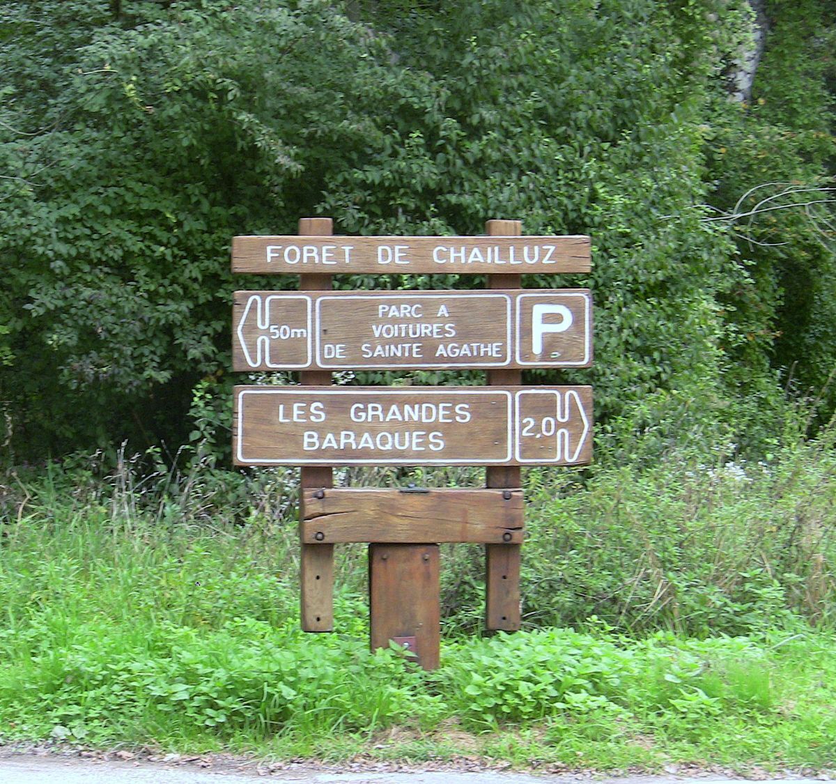 Ein hölzernes Hinweisschild mit verschiedenen Zielen.
