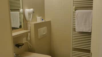 A compact bathroom with a sink, toilet, and a towel rack with a towel.