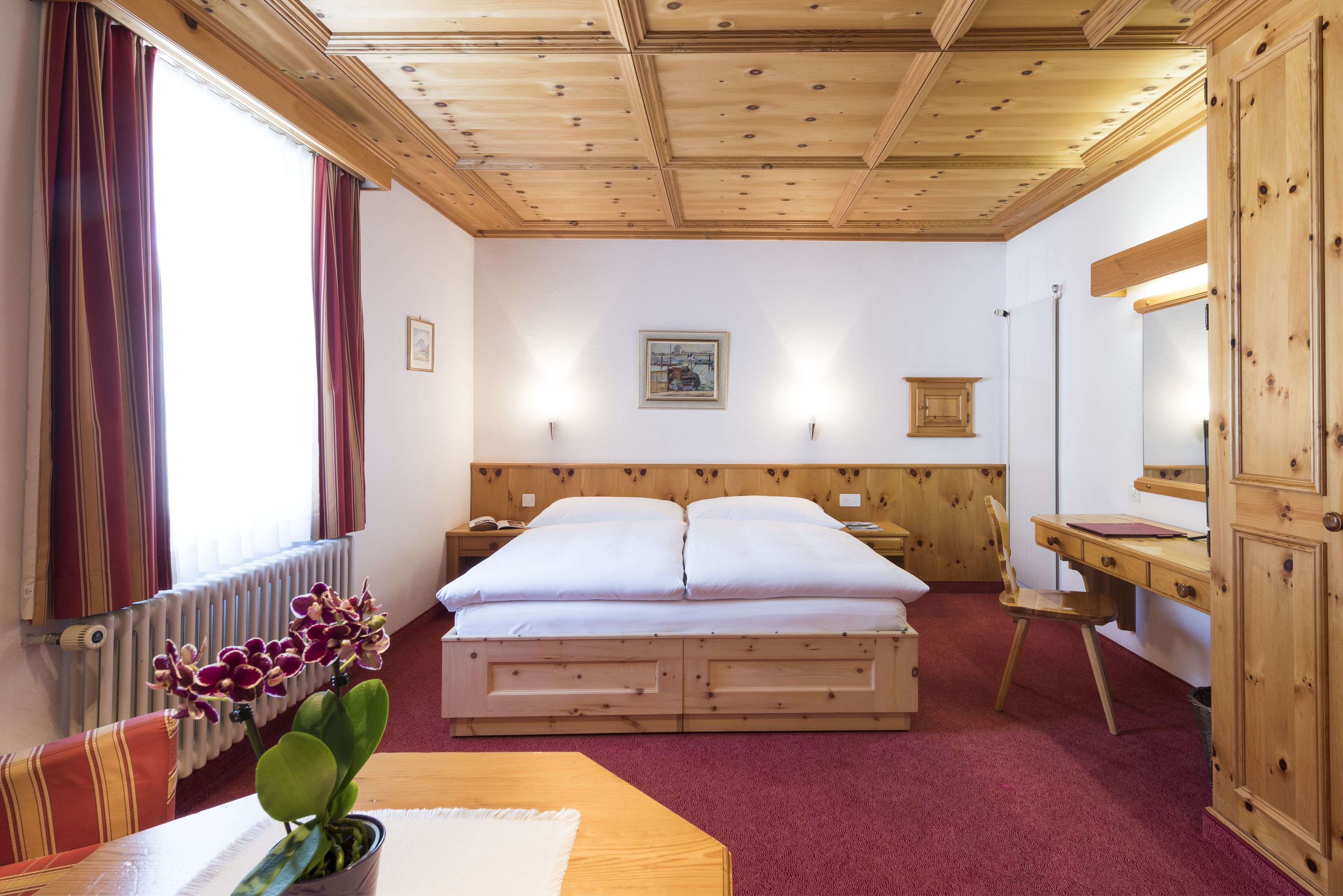 Une pièce avec un cadre en bois, comprenant un lit, un bureau et une chaise.