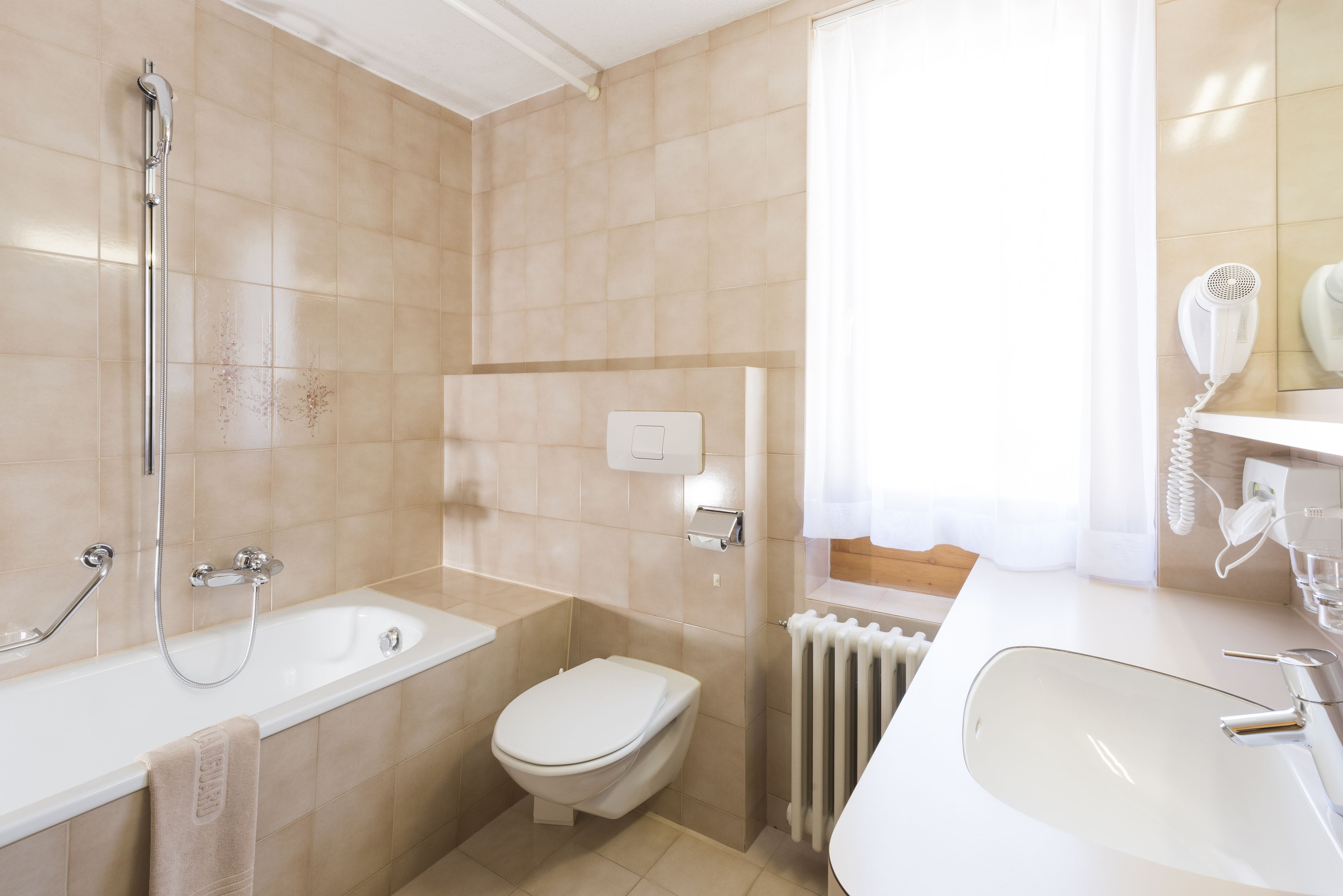 A modern bathroom with a bathtub, toilet, and sink.