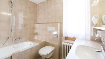 A modern bathroom with a bathtub, toilet, and sink.